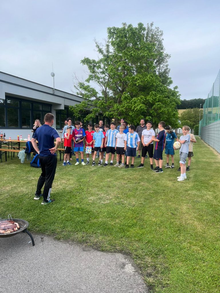 Die Spieler der U11 der SPG DER Club genießen beim Saisonabschluss gemeinsam Grillwürstel und Getränke. Nach dem Abschlusstraining stand das gemütliche Beisammensein im Mittelpunkt.